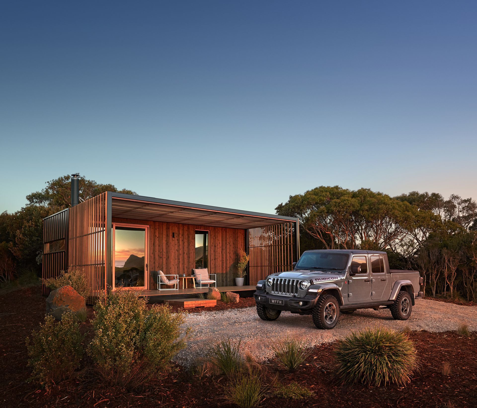 A jeep is parked in front of a small wooden house