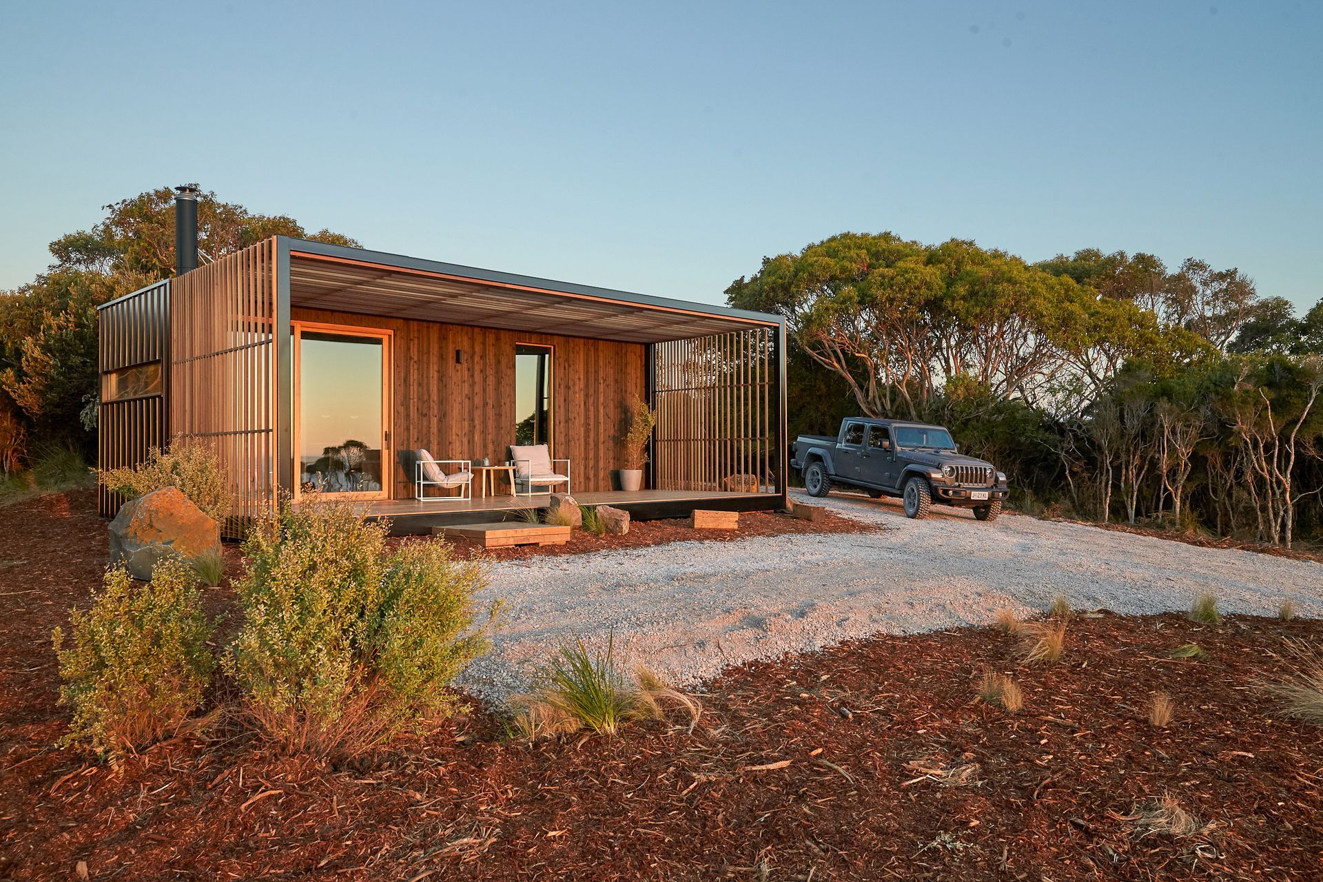 A small wooden house with a truck parked in front of it.