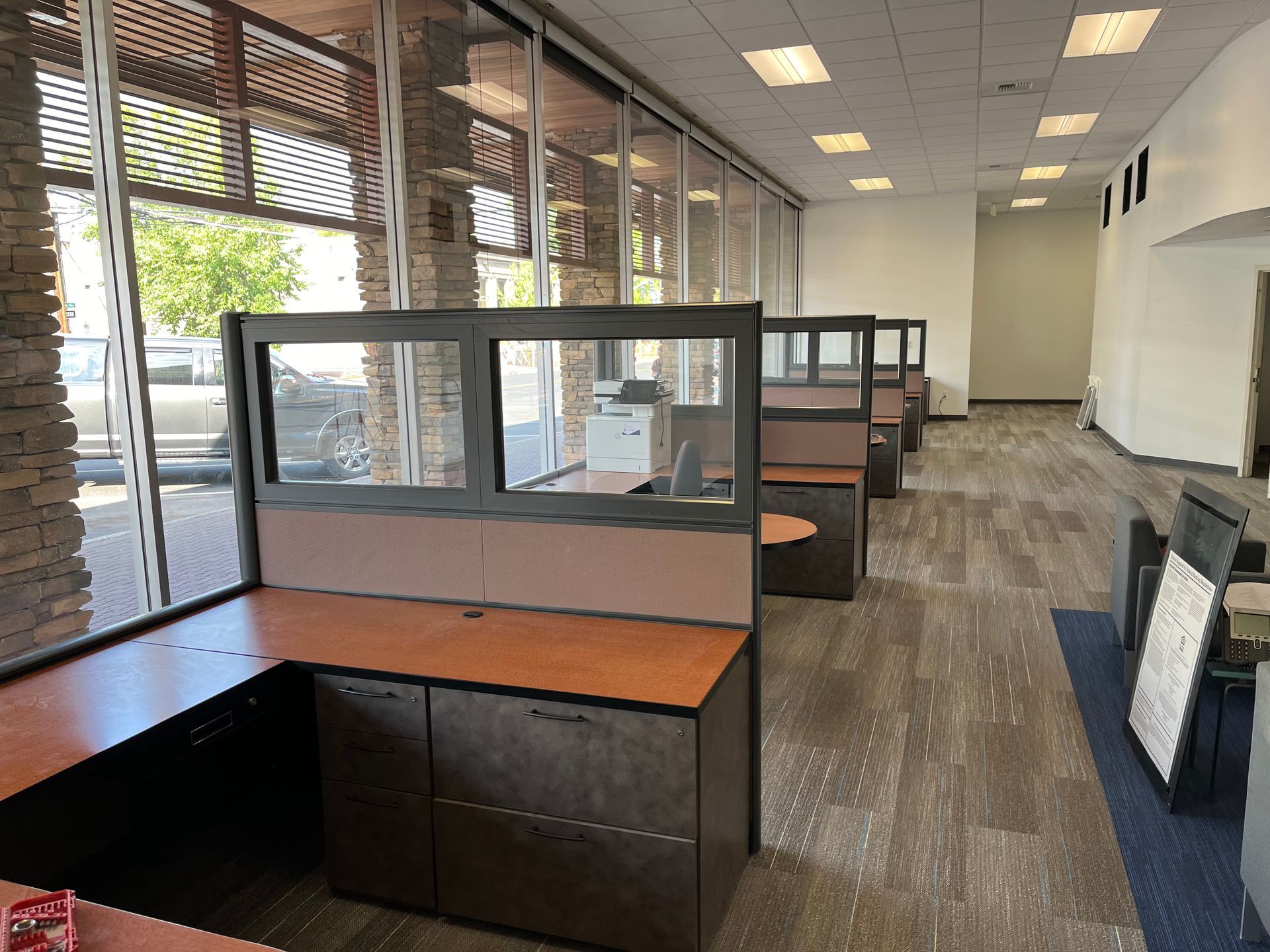 An empty office with cubicles and a lot of windows.