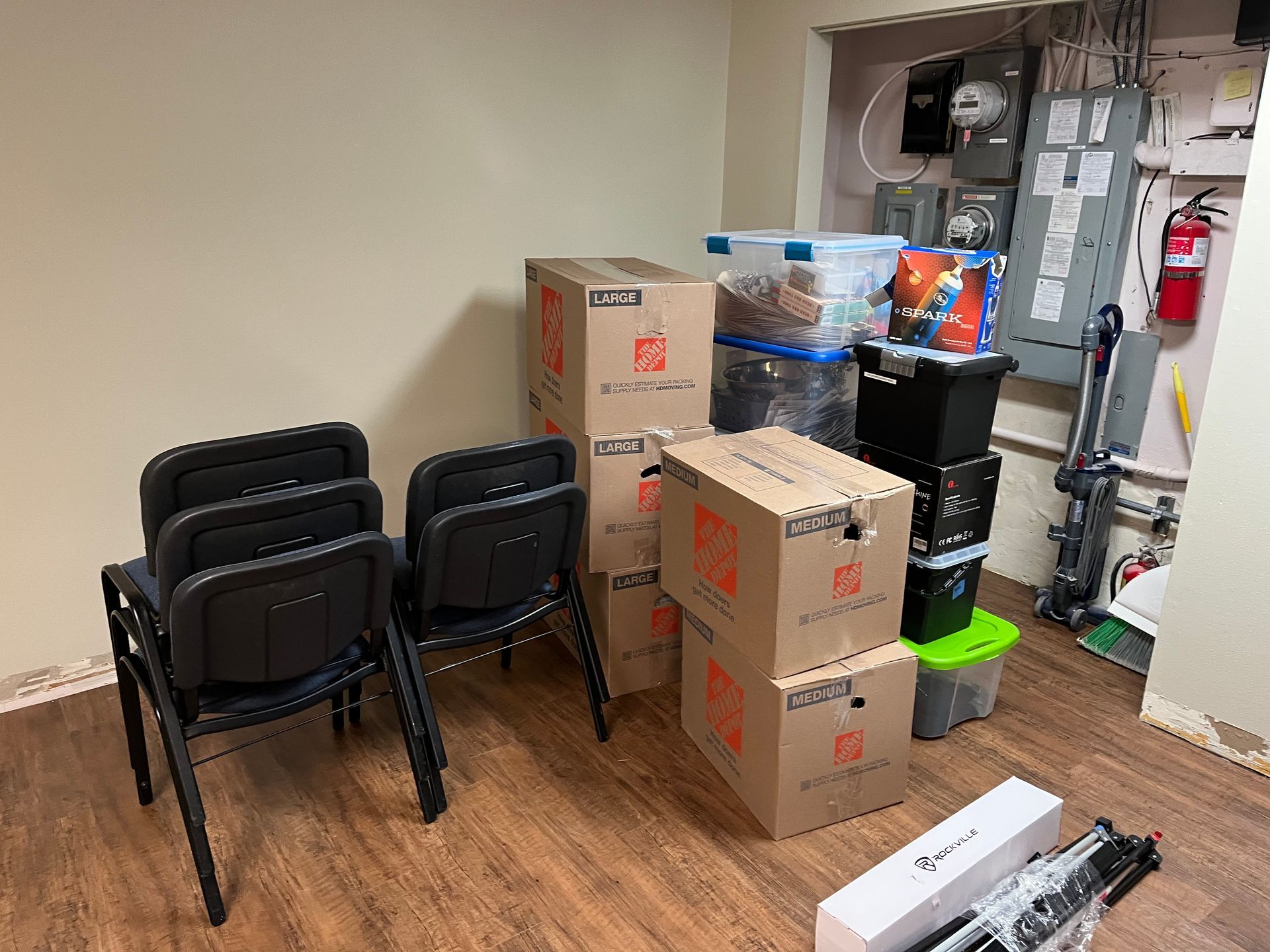 A living room with a piano covered in plastic and a painting on the wall.