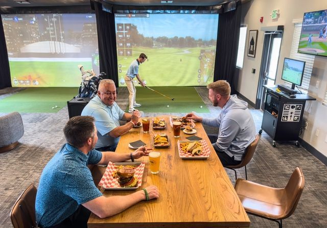 A bride in a wedding dress is sitting on the ground holding a bouquet of flowers.