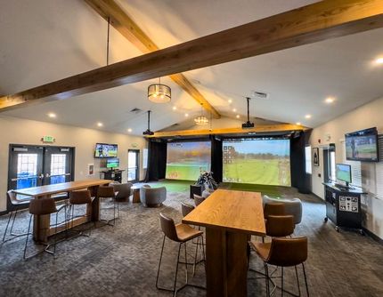 There is a golf simulator in the middle of the room.