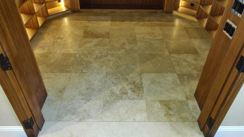 Stone floor with arched wooden door frames and a wooden wine rack.