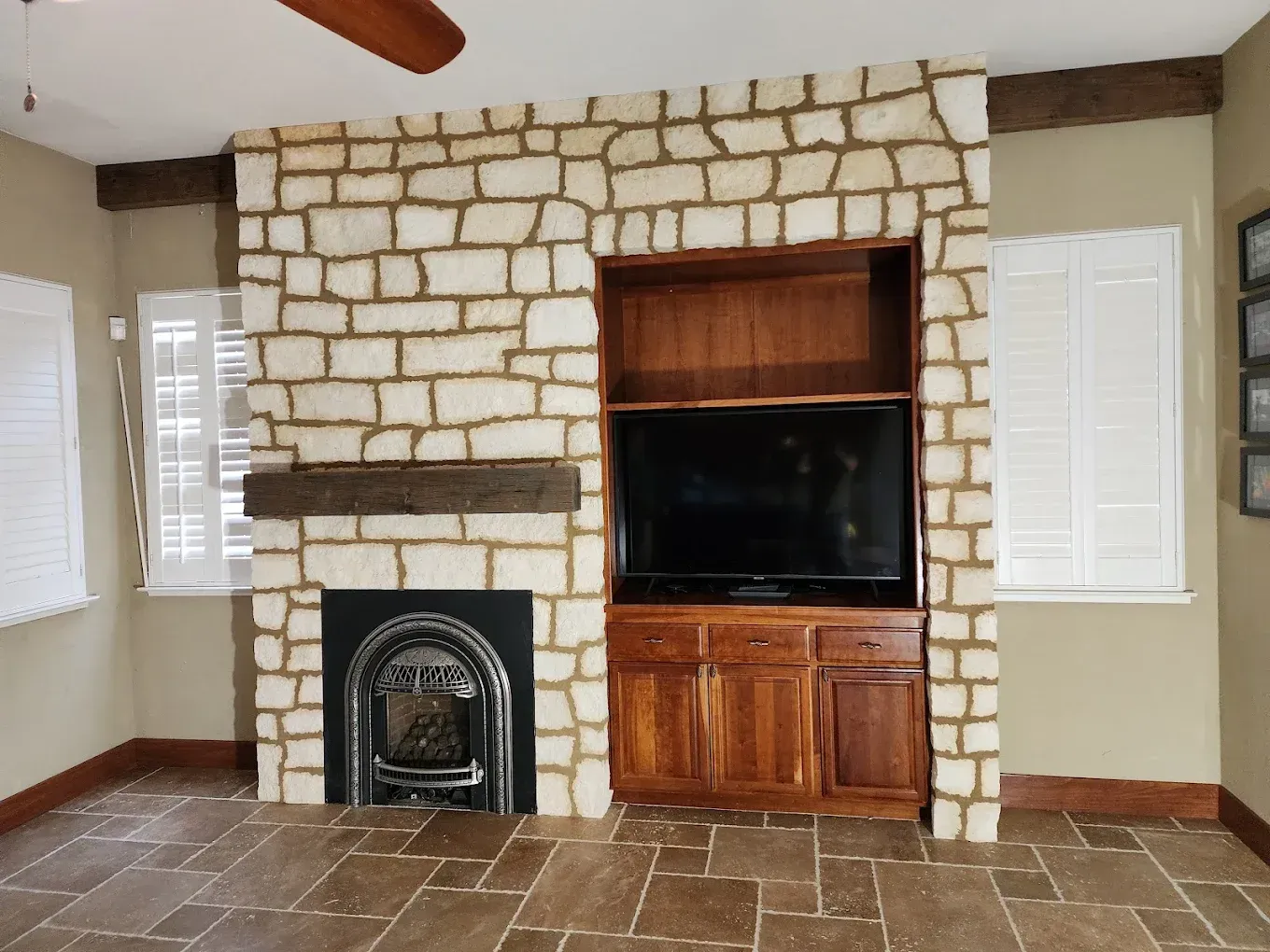 A living room with a stone fireplace and a flat screen tv