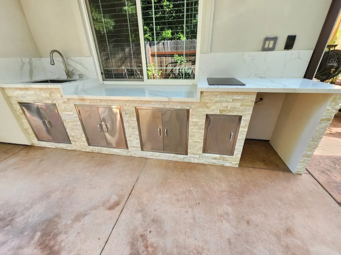 A kitchen with a sink , cabinets , and a window.