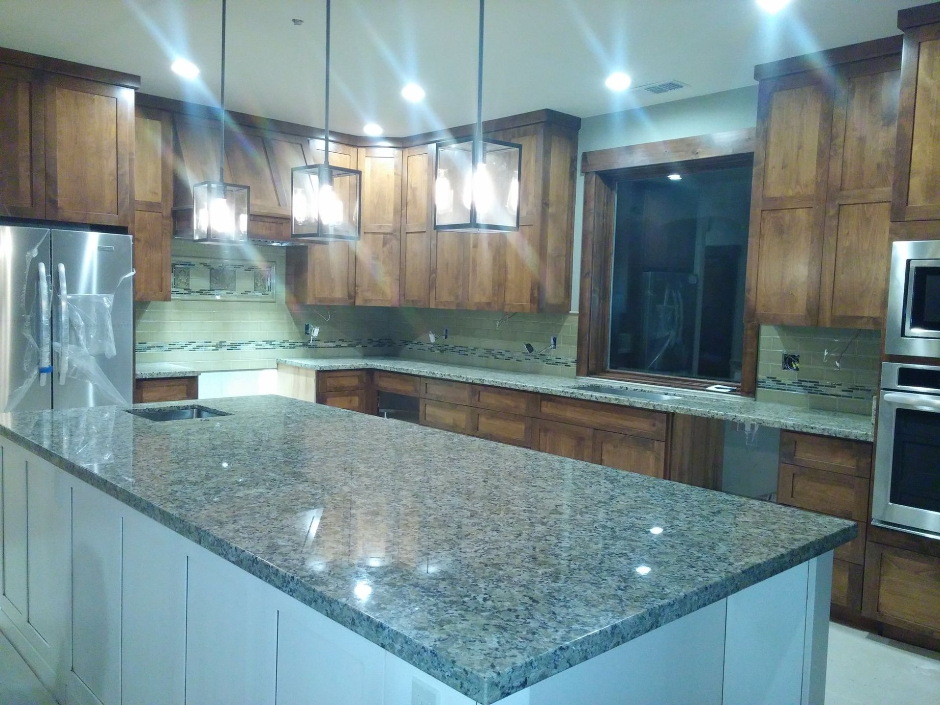 A kitchen with granite counter tops and wooden cabinets