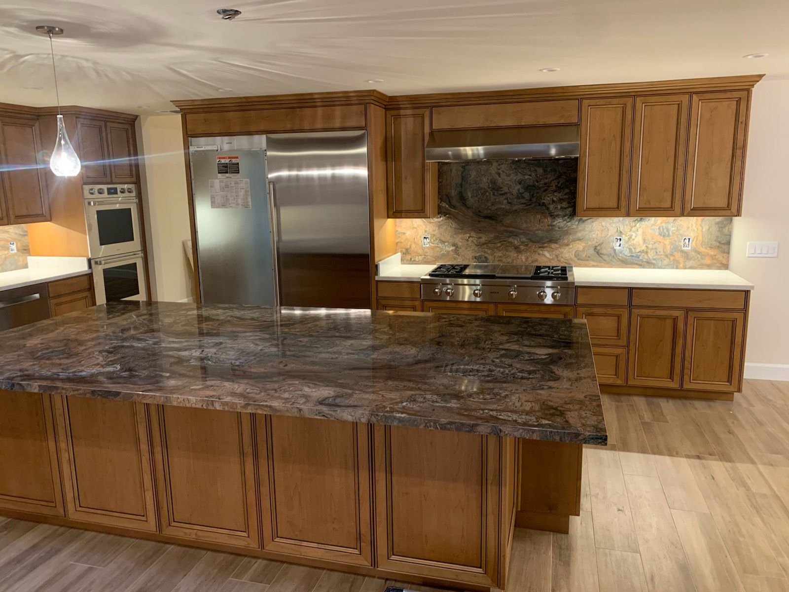 A kitchen with granite counter tops and wooden cabinets
