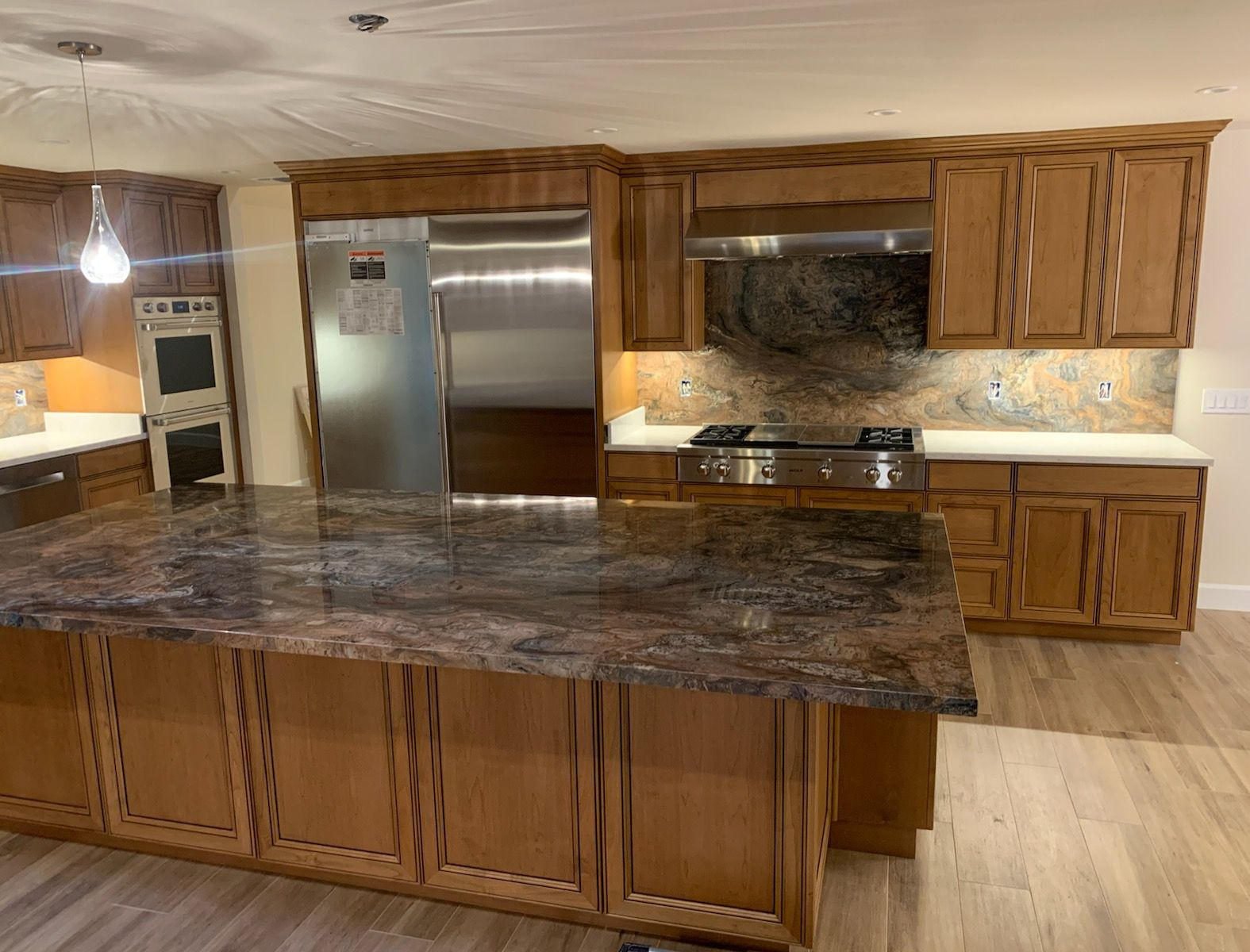 A kitchen with granite counter tops and wooden cabinets
