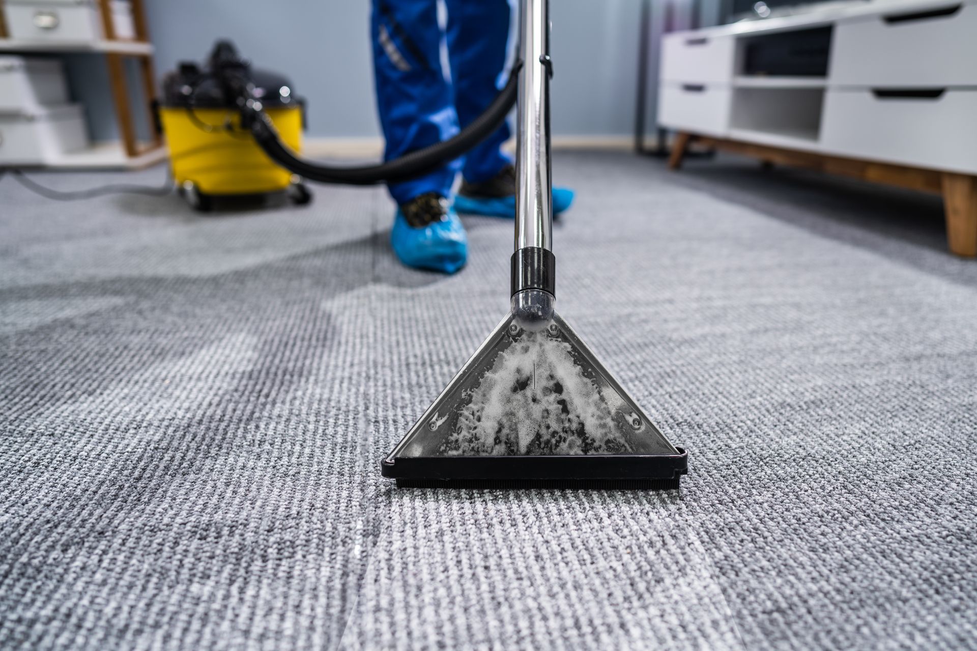 A vacuum cleaner is sitting on a carpet in a room.