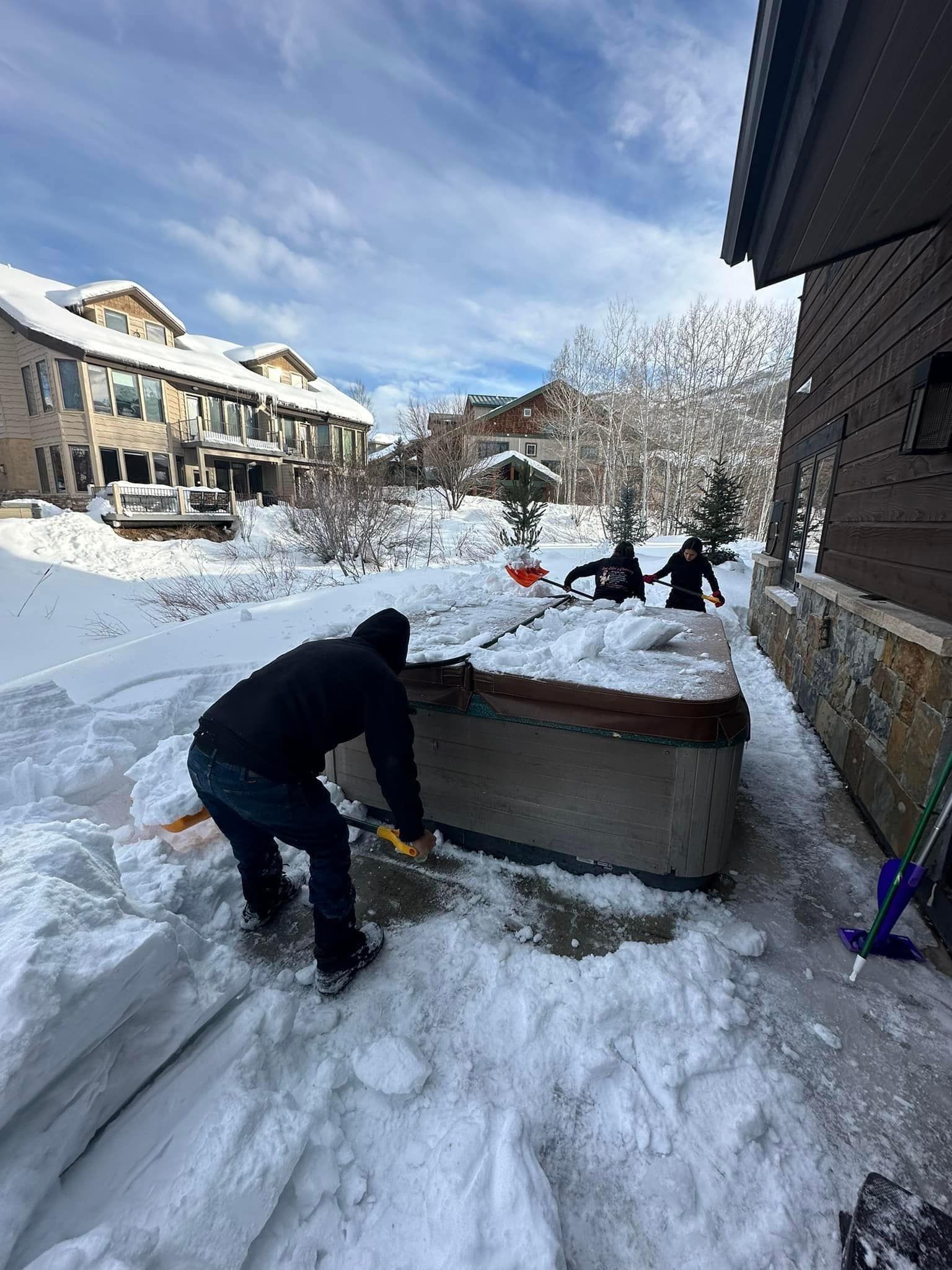 A person is shoveling snow with a red shovel.