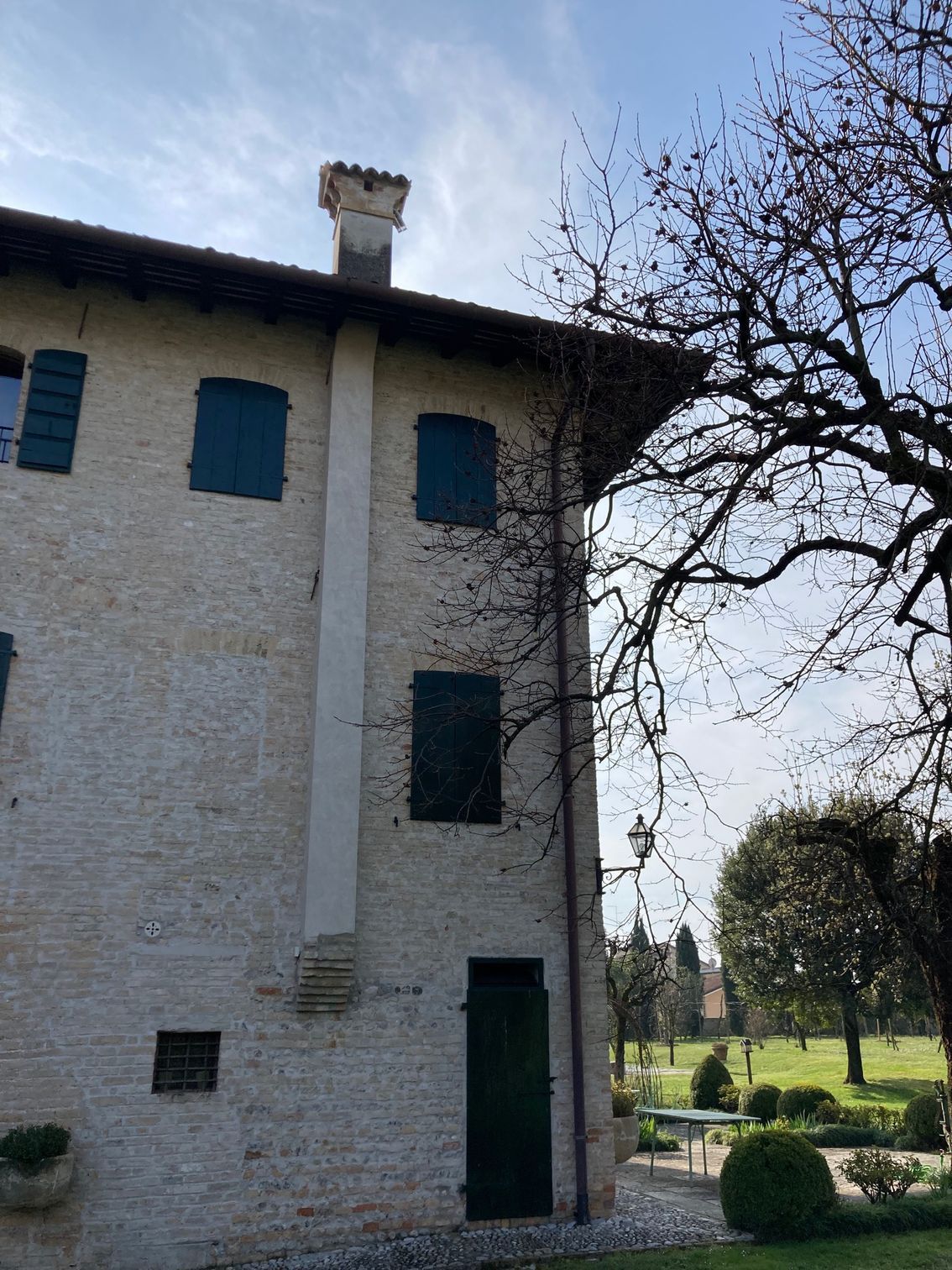 Un grande edificio in mattoni con persiane blu e un camino