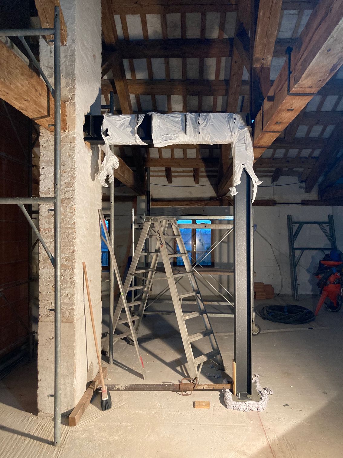 Una scala è appoggiata al centro di un edificio in costruzione.