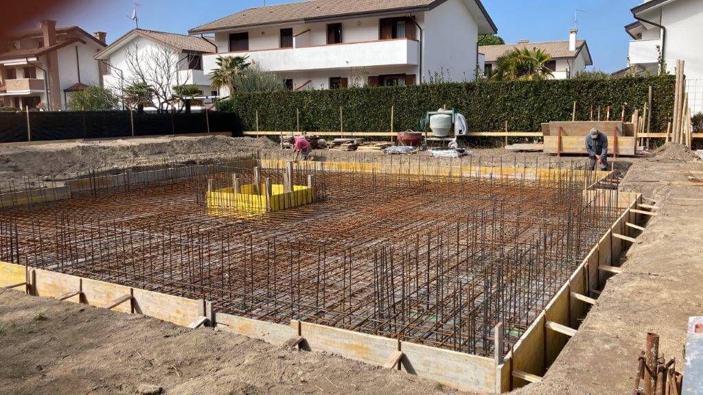 Un cantiere con una casa sullo sfondo