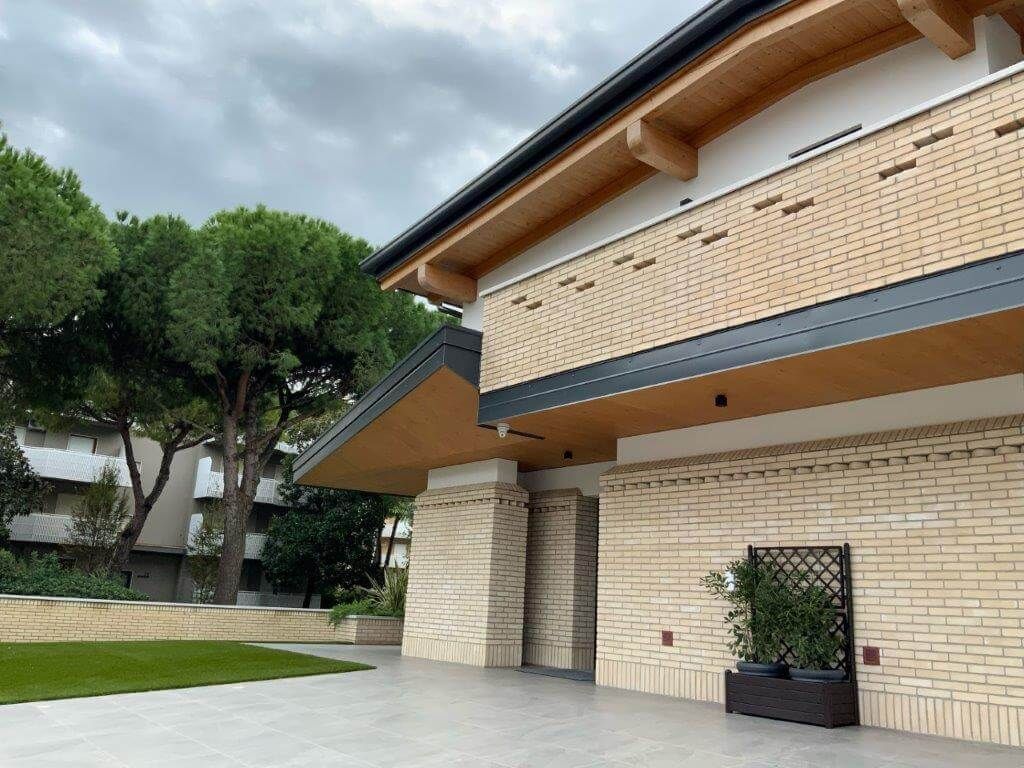 Un grande edificio in mattoni con un balcone e alberi sullo sfondo