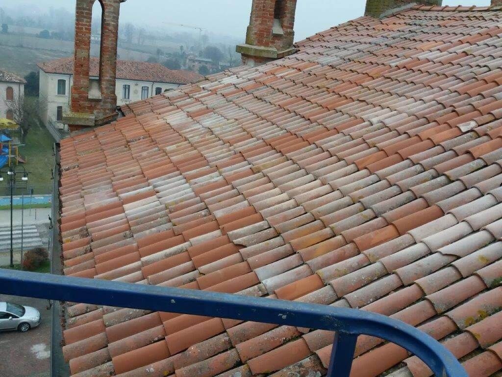 Un tetto con un sacco di tegole e camini sopra