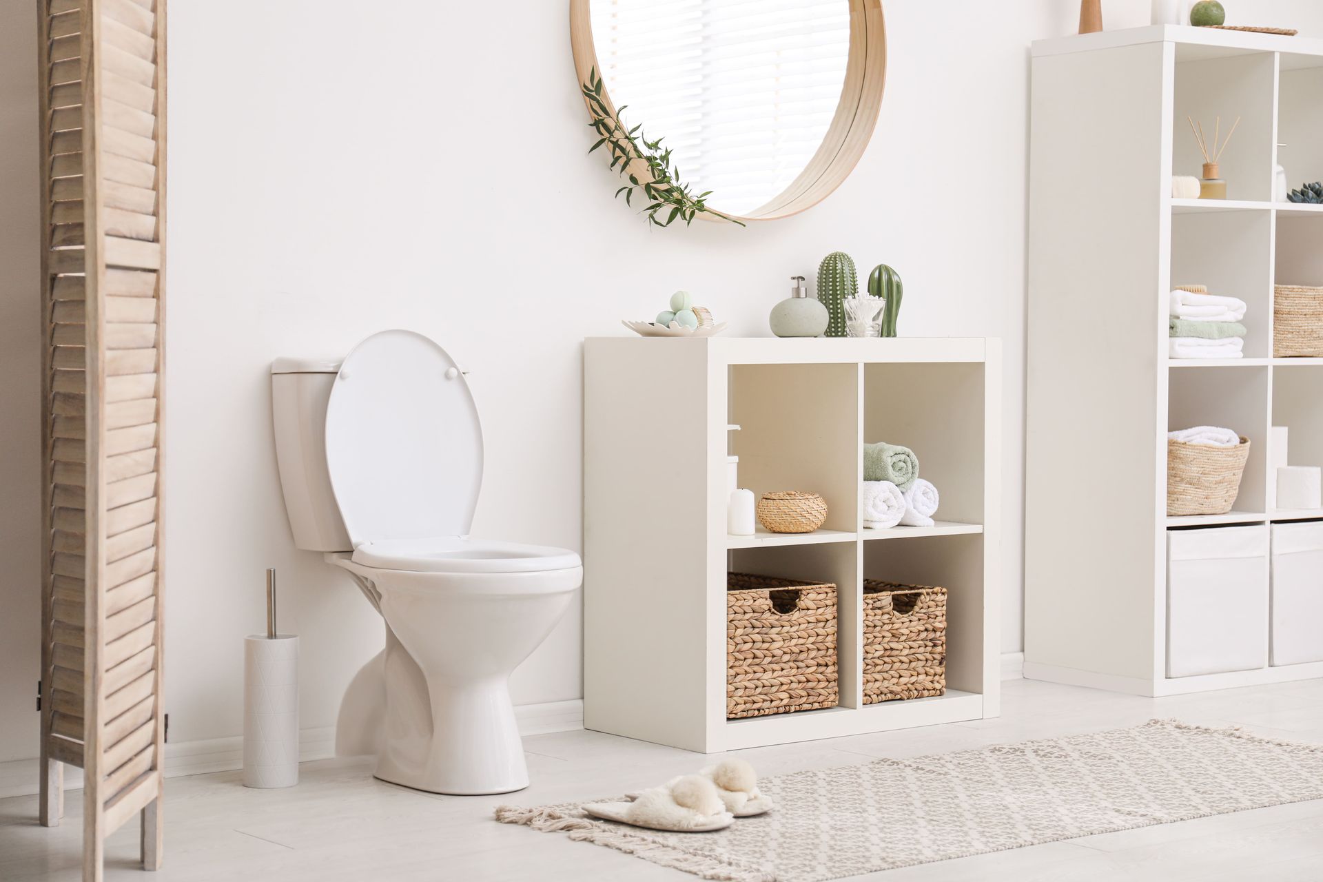 A bathroom with a toilet , sink , mirror and shelf.