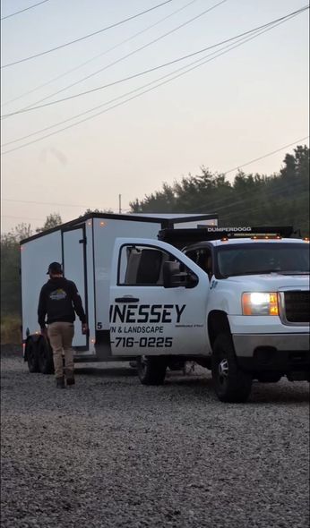 Man walks towards white truck and trailer.