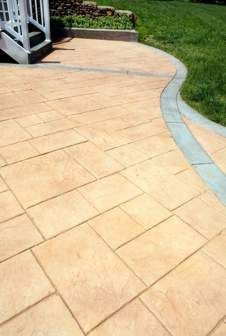 Beige stamped concrete patio with a grey concrete border.