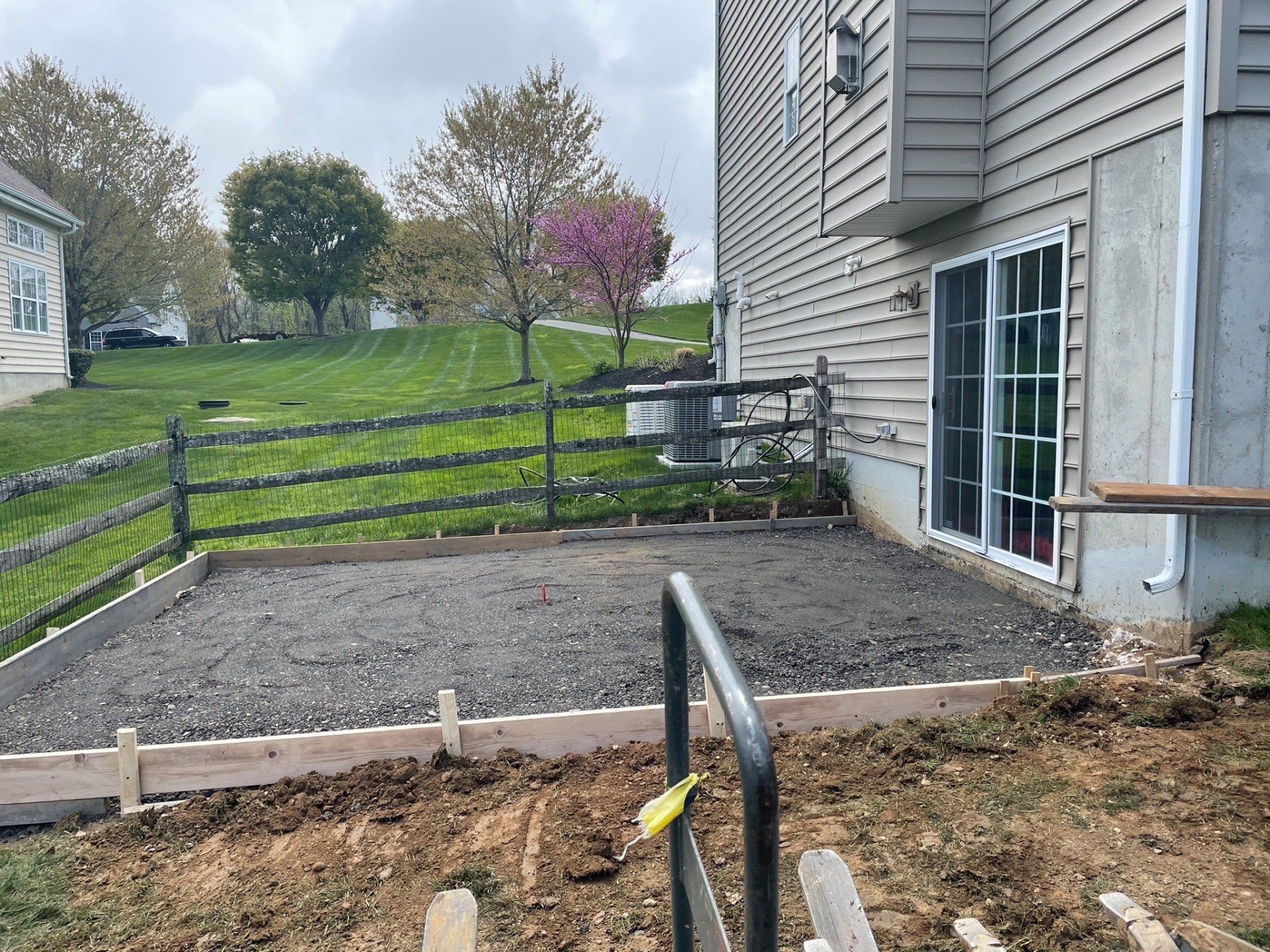 Concrete patio being prepared outside of patio doors in the backyard of a house.