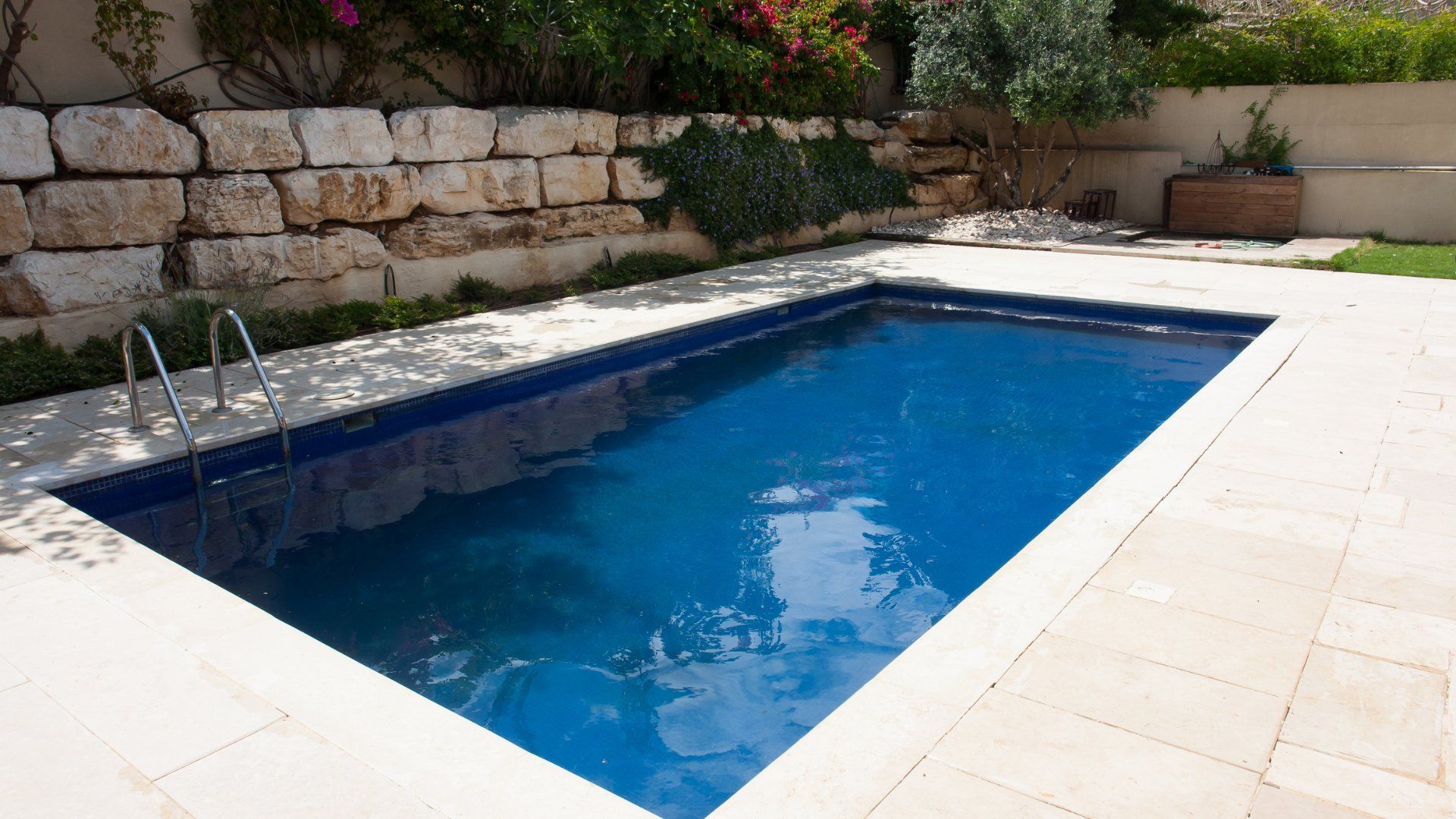 Small backyard pool with a simple stamped concrete pool deck.