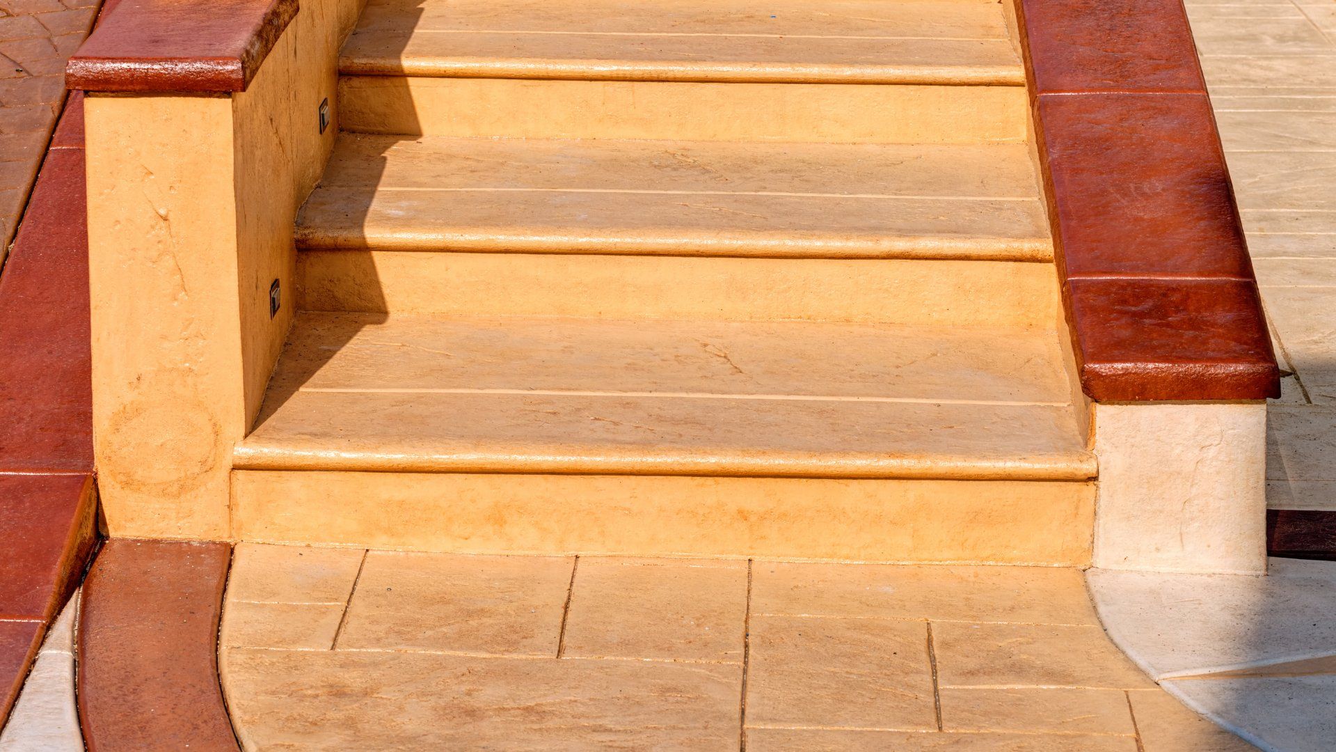 Coloured concrete steps with a brown concrete border.