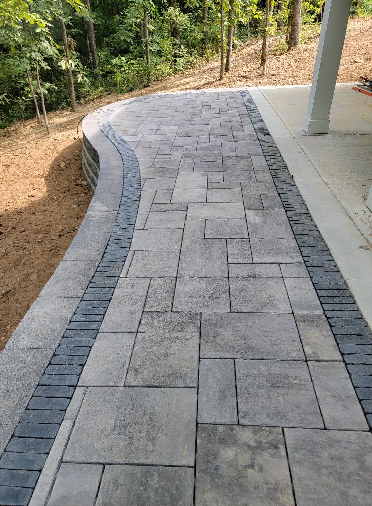 Picture of a stamped concrete walkway along the edge of a patio.  The concrete sidewalk was installed by a local concrete company in Kingston Ontario.