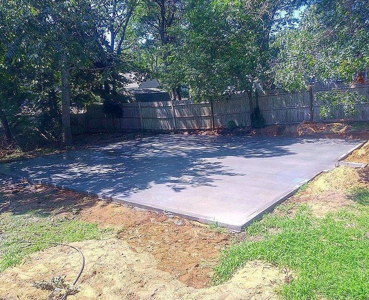 Concrete slab on grade in a backyard.  It may be used for a garage, shed or patio.