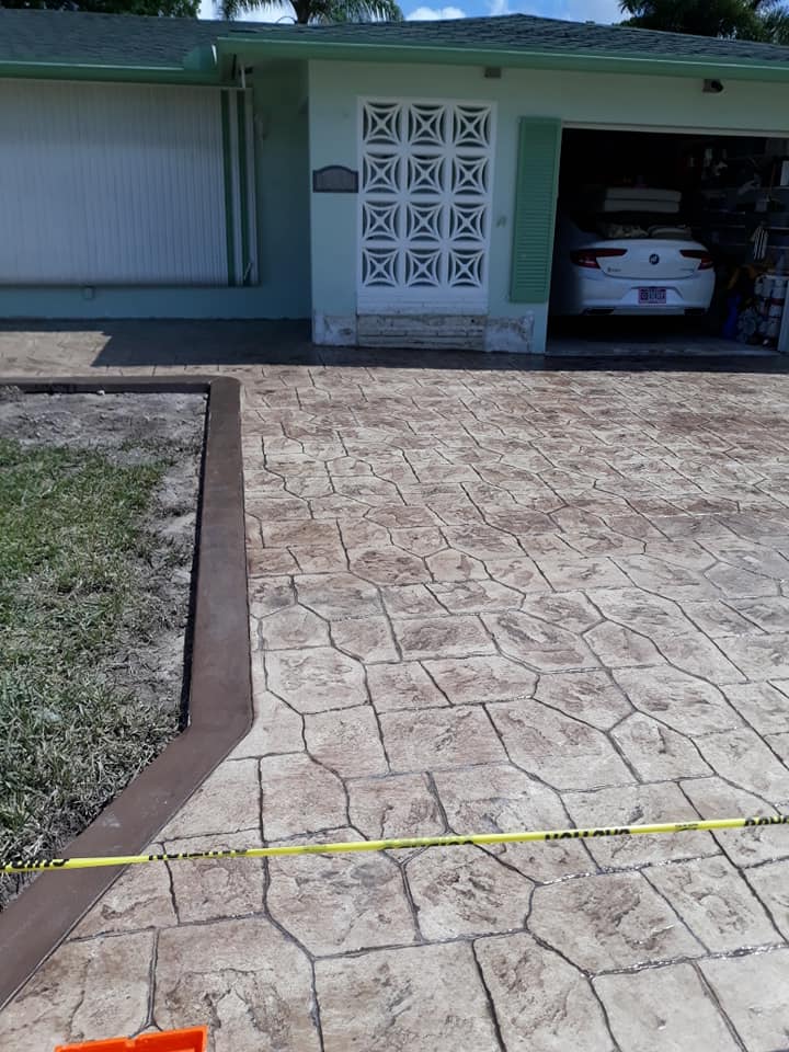 Stamped concrete design on a new driveway.  The driveway has a brown concrete border.