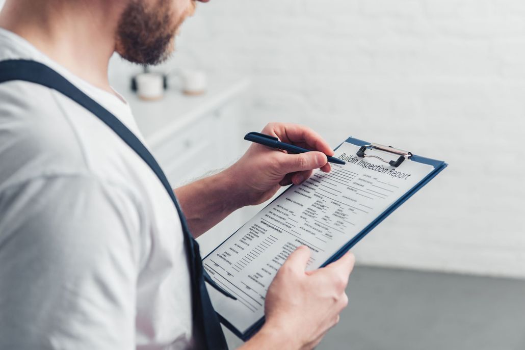 A man is writing on a clipboard with a pen.