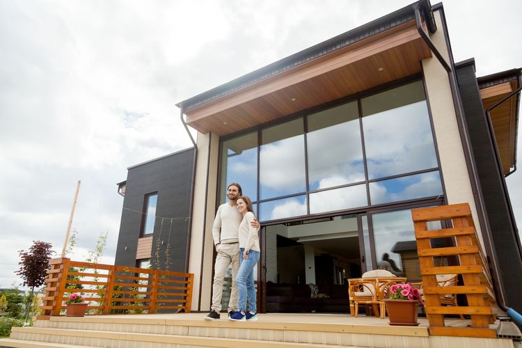 Couple standing on porch of modern house 