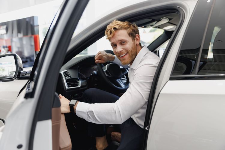 Man sitting in the driver's seat of a white car