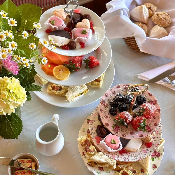 A table topped with plates of food and flowers