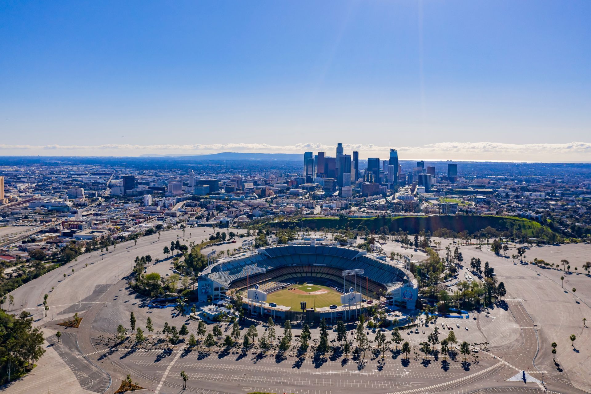 An aerial view of a baseball stadium with a city in the background.