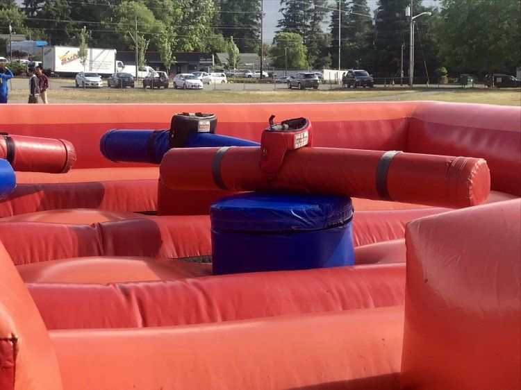 A bunch of inflatable toys are sitting on top of each other in a field.
