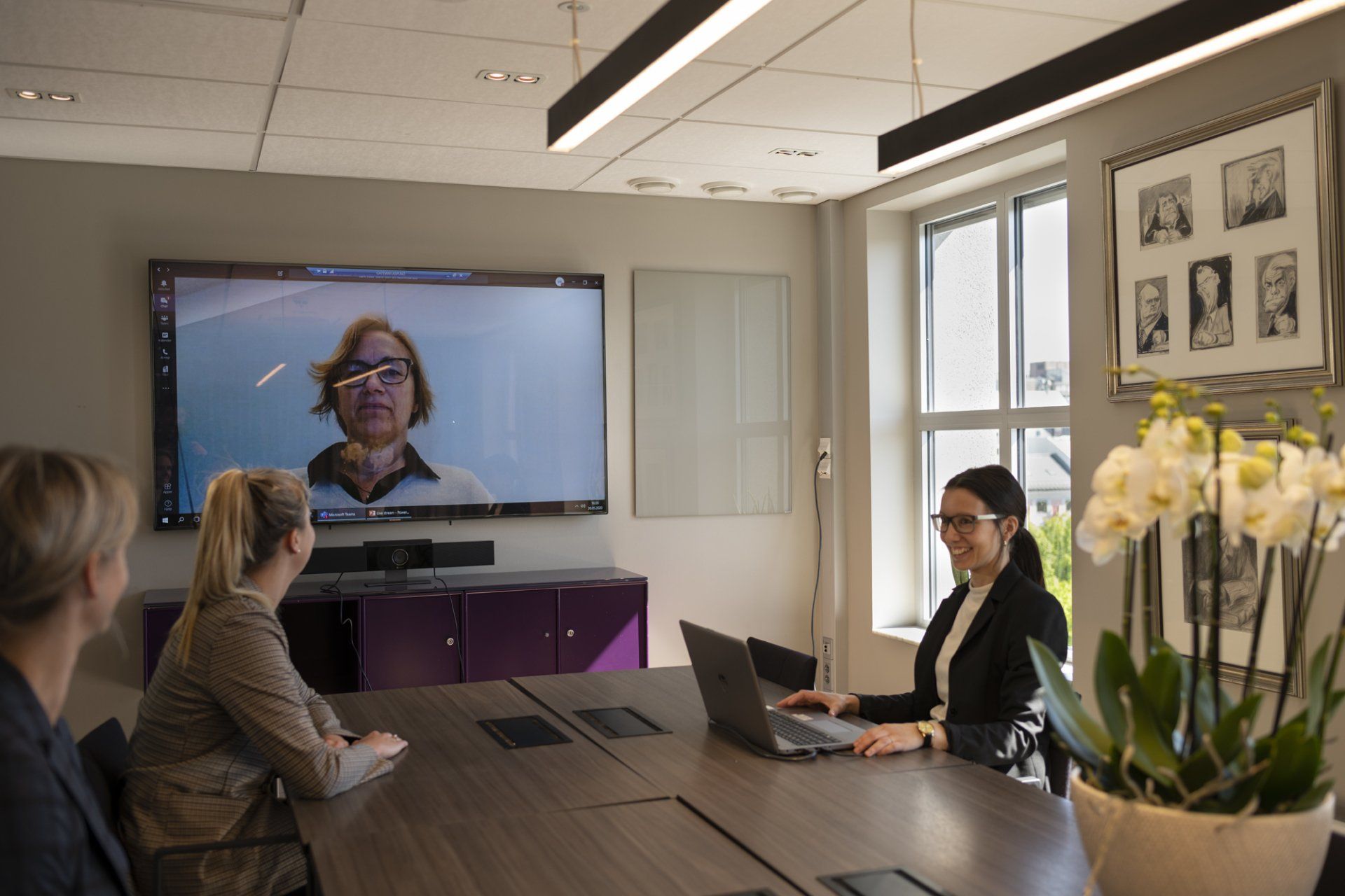 Tre damer på Høyres Hus som har videomøte med noen på storskjerm