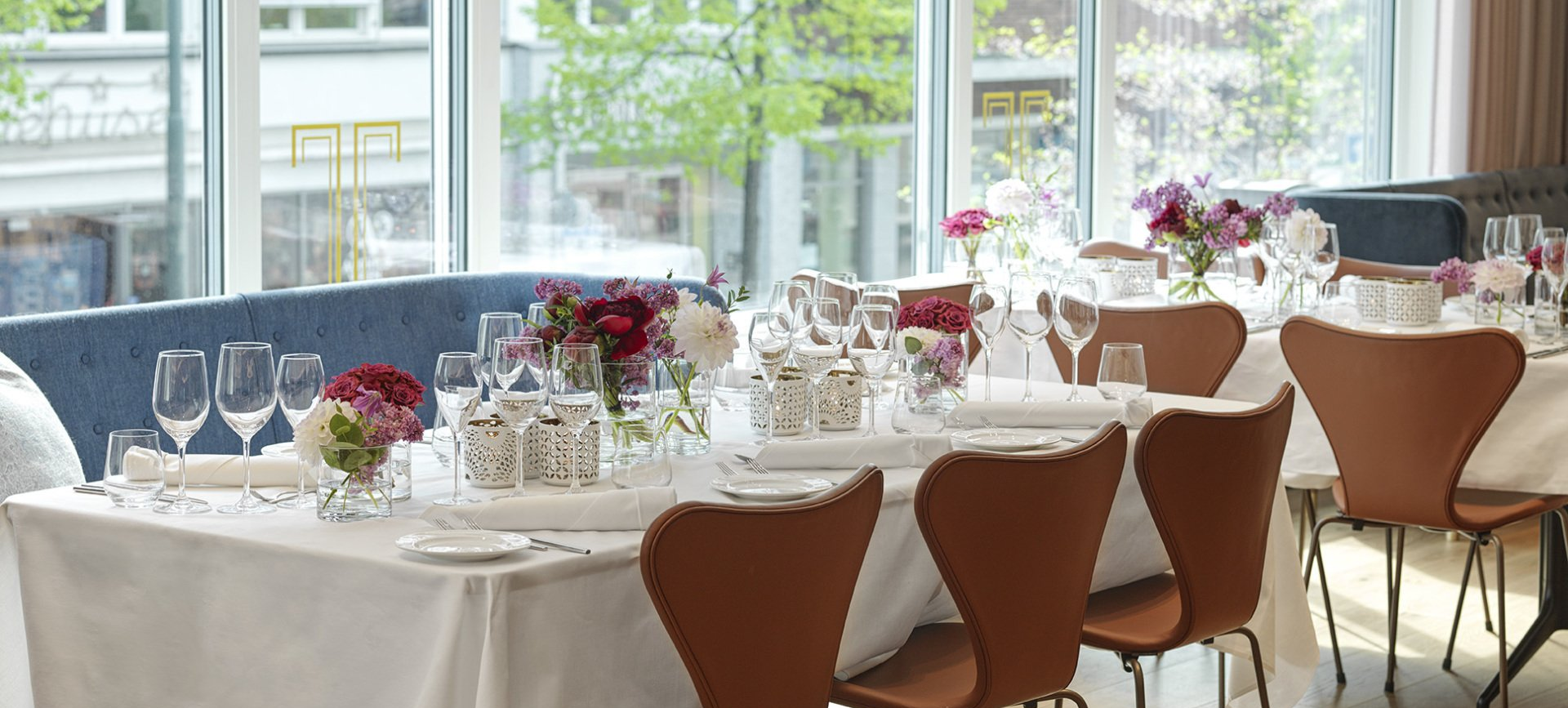 Bord på restaurant Tivander dekket og pyntet med blomster til firmafest