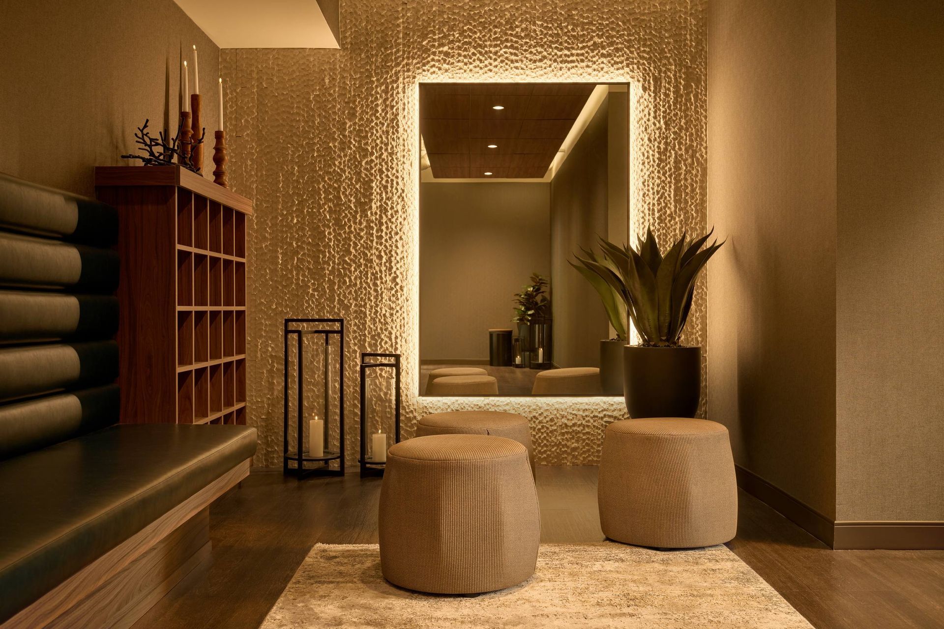 Spa interior with a large mirror, two stools, and a bench.