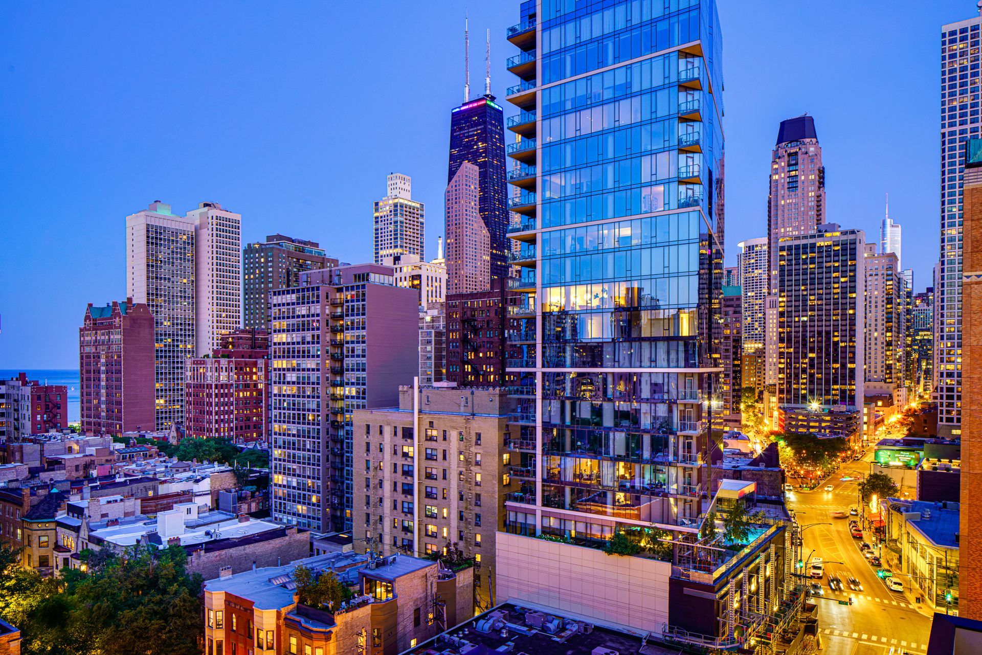 An aerial view of a city skyline at night with a tall building in the foreground.