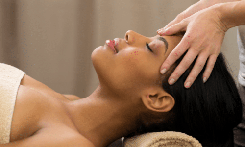 A woman is getting a head massage at a spa.