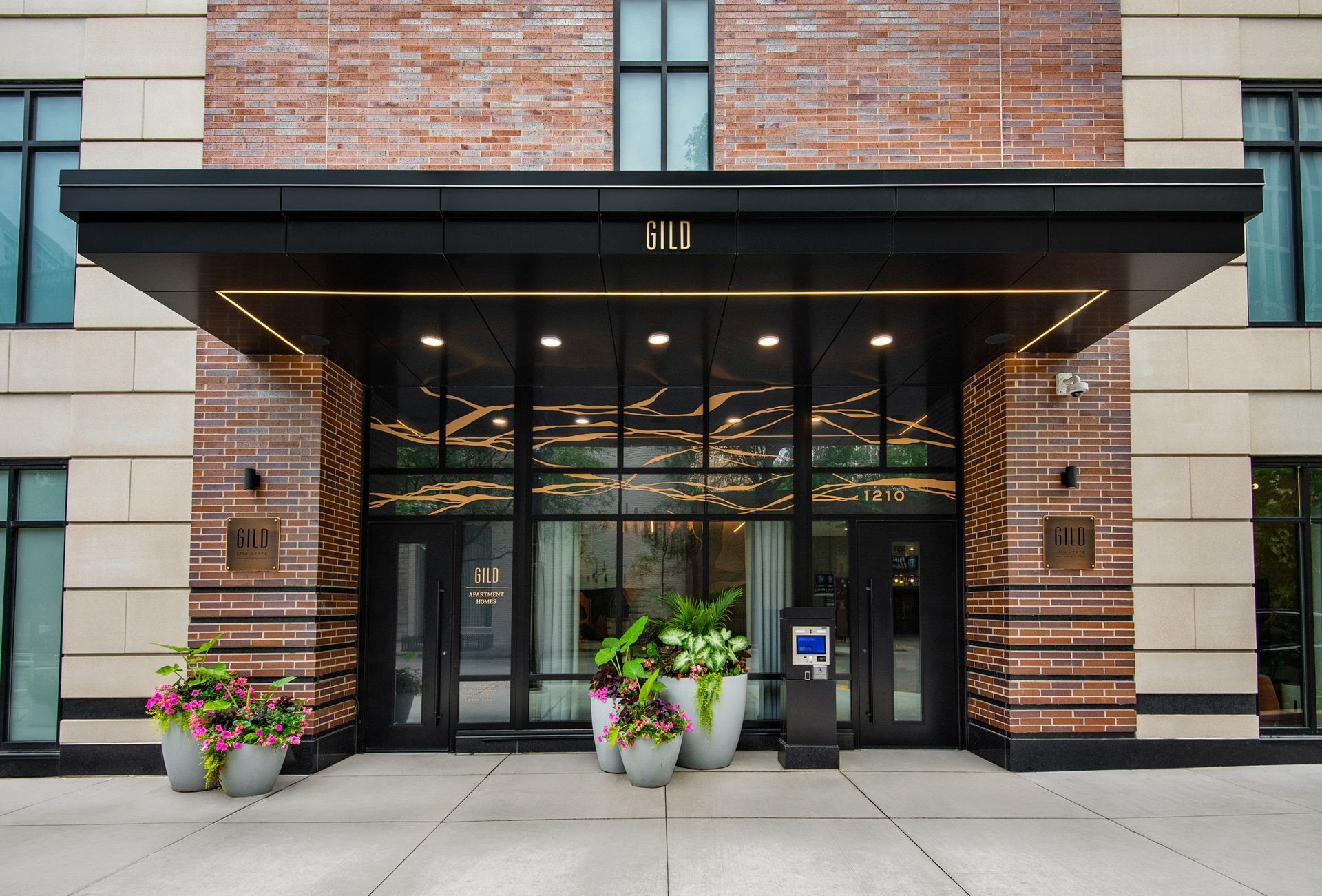 Gild apartment building front entrance with glass doors.