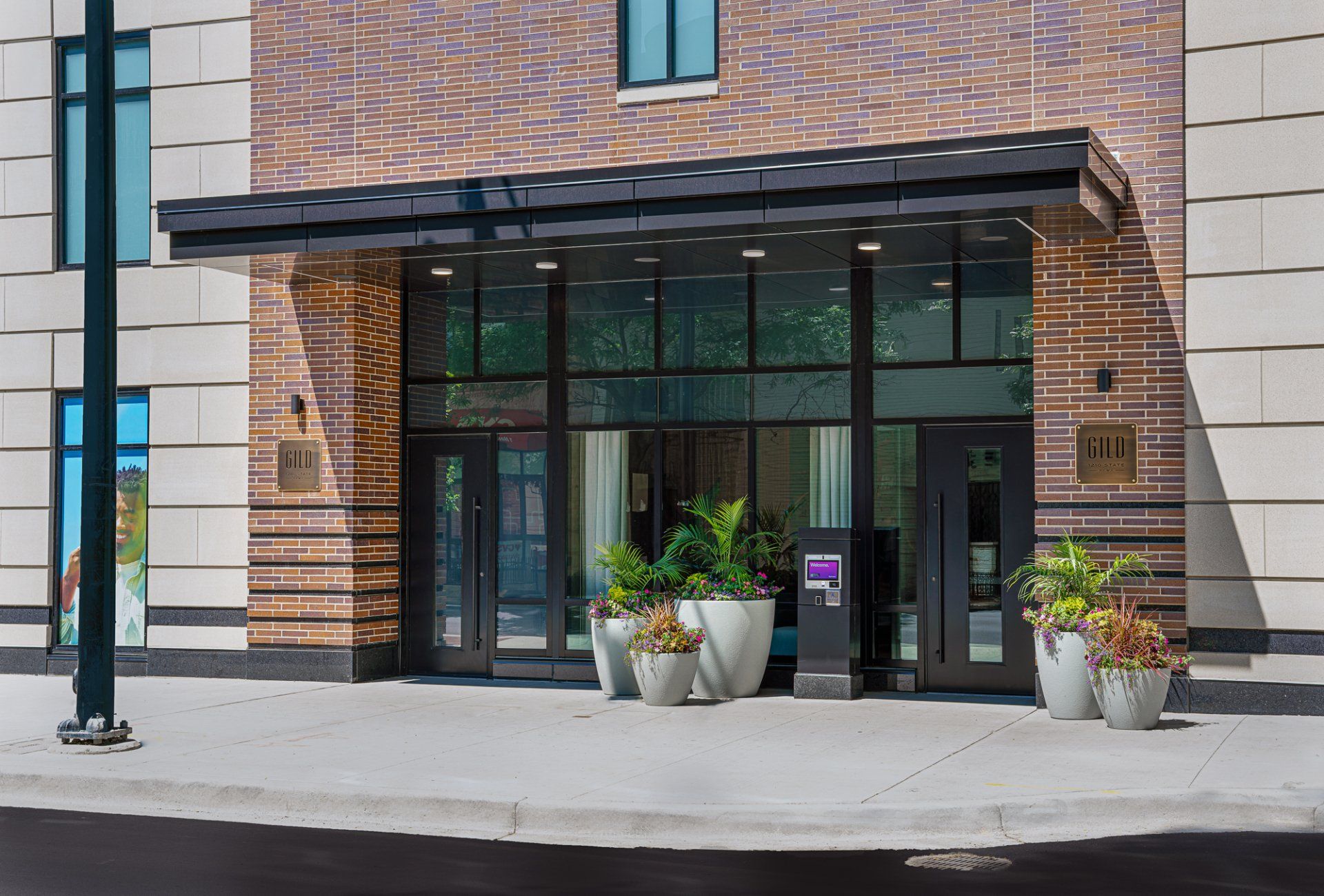 Gild apartment building front entrance with glass doors.