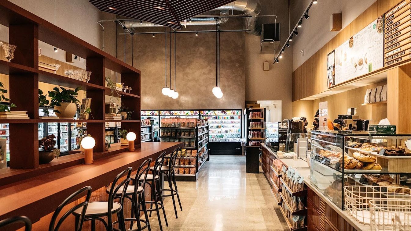 The inside of a restaurant with a long bar and stools.