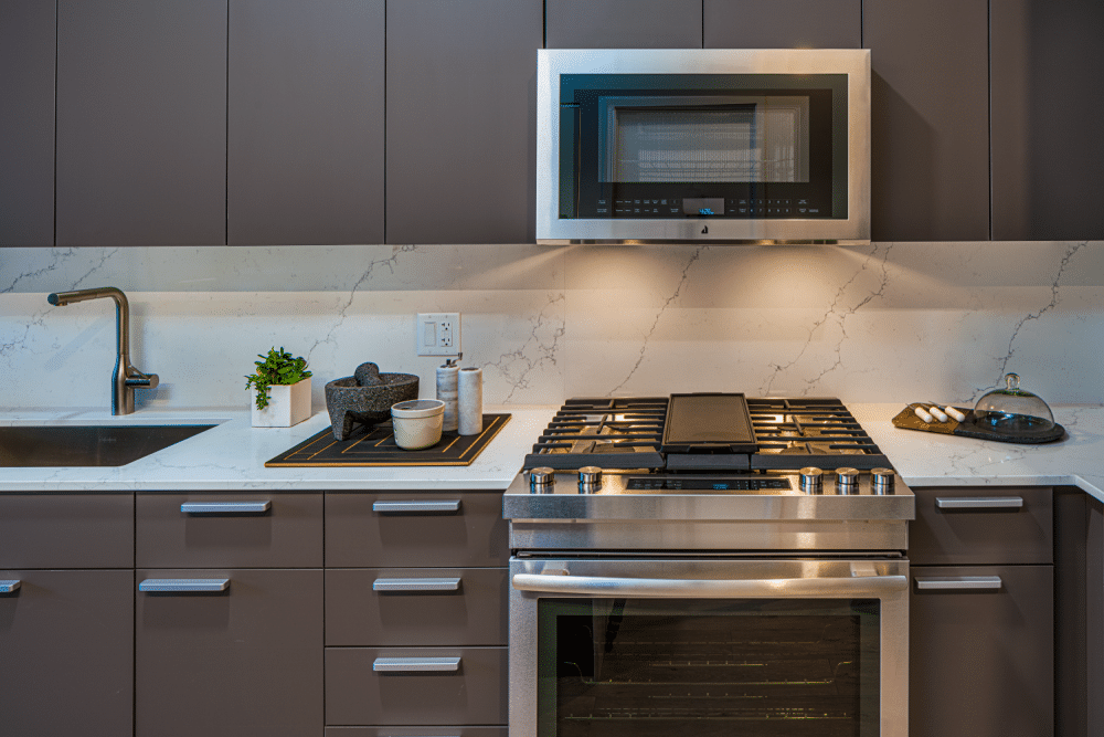 Modern kitchen at Gild Apartment with gas stovetop and microwave.