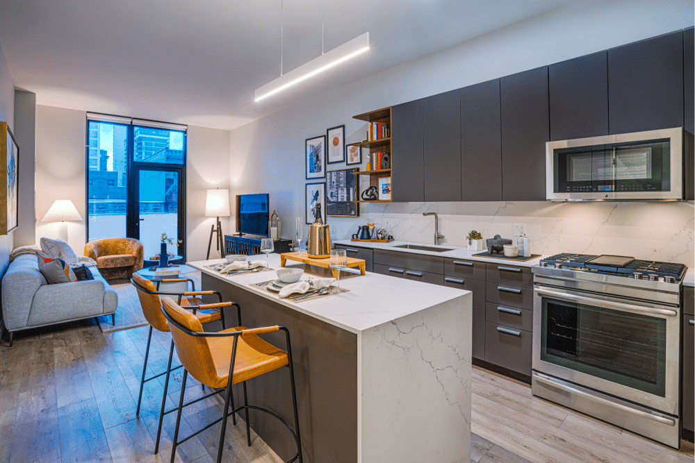 Spacious kitchen with oversized island oversees the living room and the balcony at Gild Apartment.