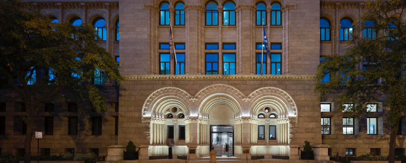 A large building with a lot of windows is lit up at night.