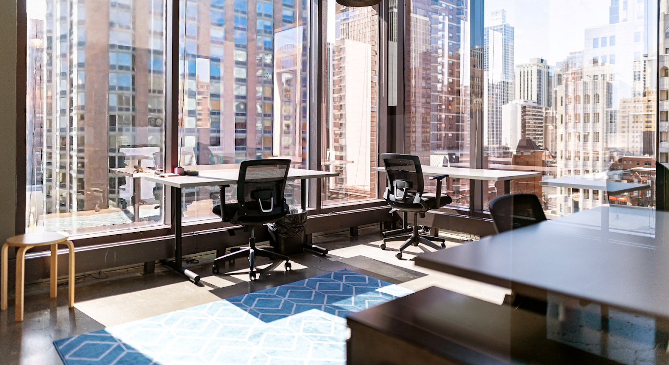 A room with a lot of windows and tables and chairs in it.