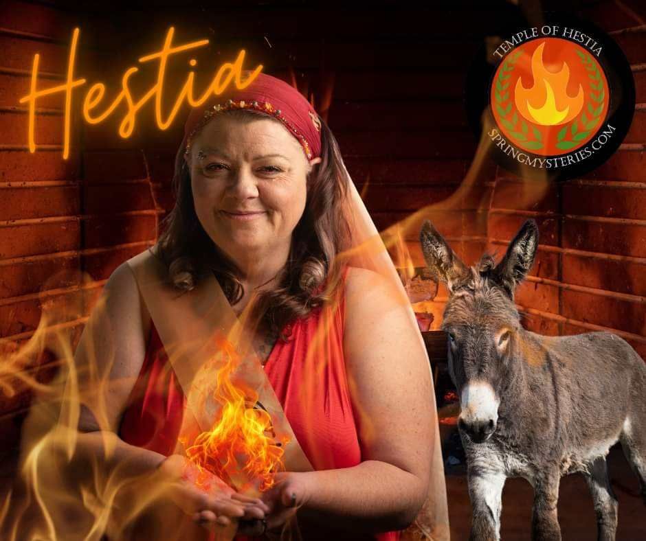 A woman is standing next to a donkey in front of a fireplace with the word hestia written on it