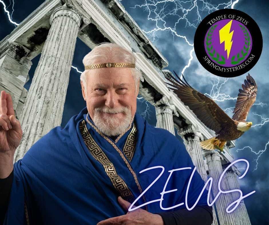 A man in a zeus costume is standing in front of a building