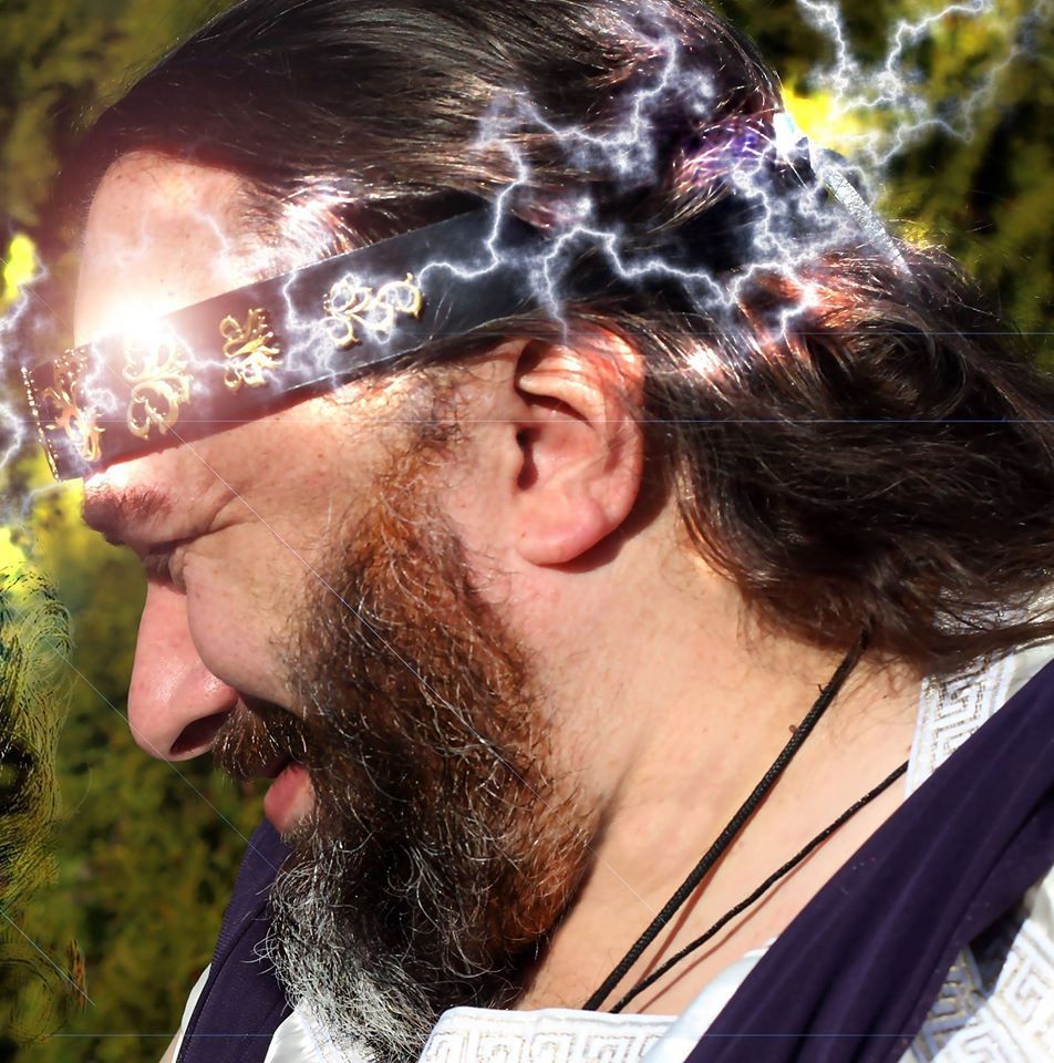 A man with a beard wearing a headband with characters on it, representing Zeus.