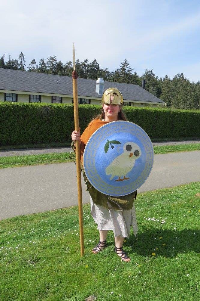 A woman wearing a helmet, holding a sword and a shield, representing Athena.